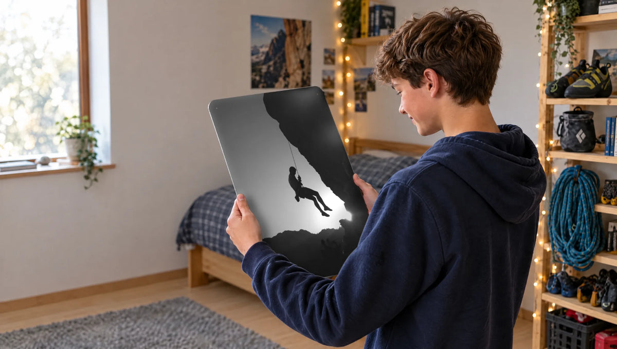 A teenage boy in his bedroom holding a black and white rock climbing photo board