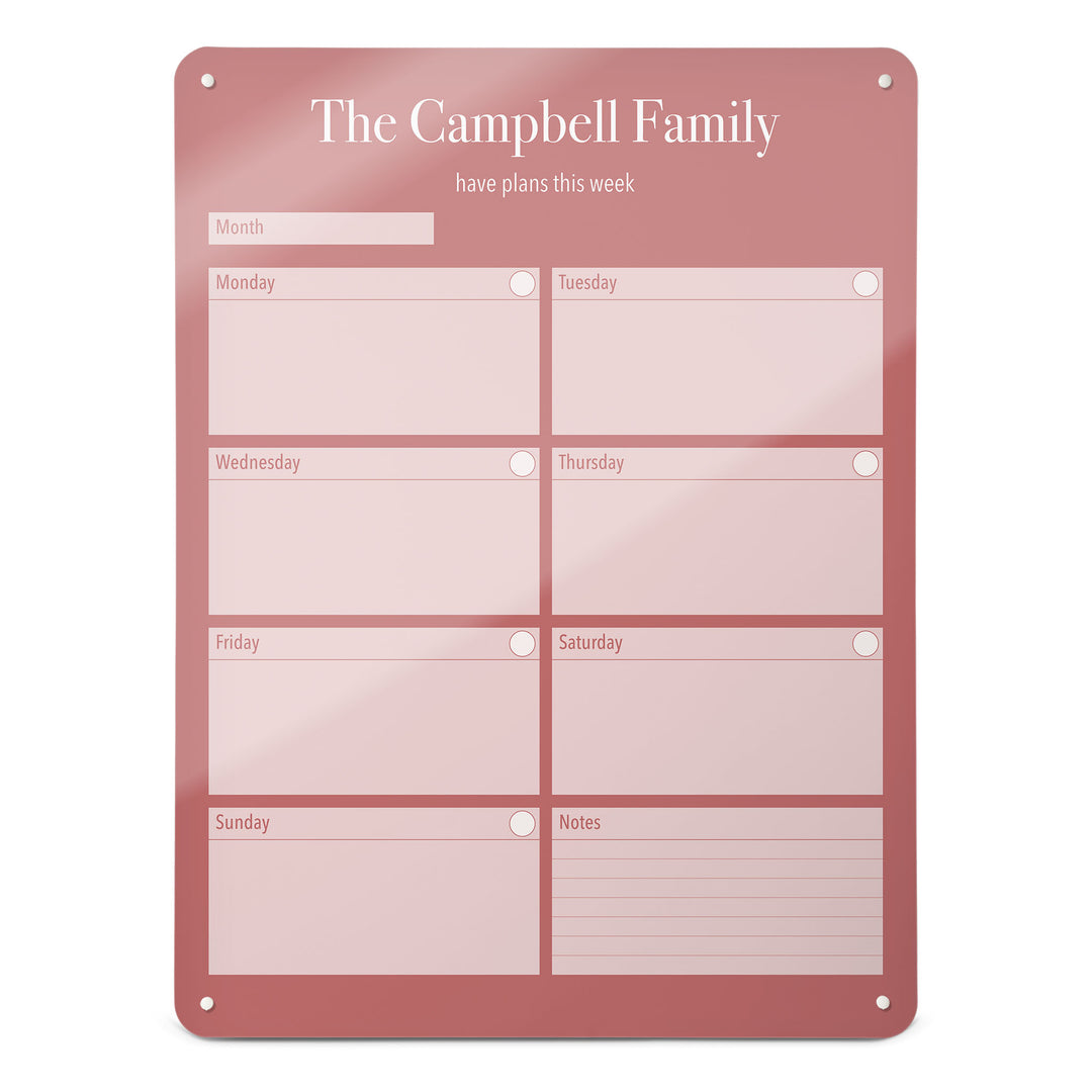 A large magnetic notice board by Beyond the Fridge with a weekly planner design to personalise  in a pink colour and portrait format 