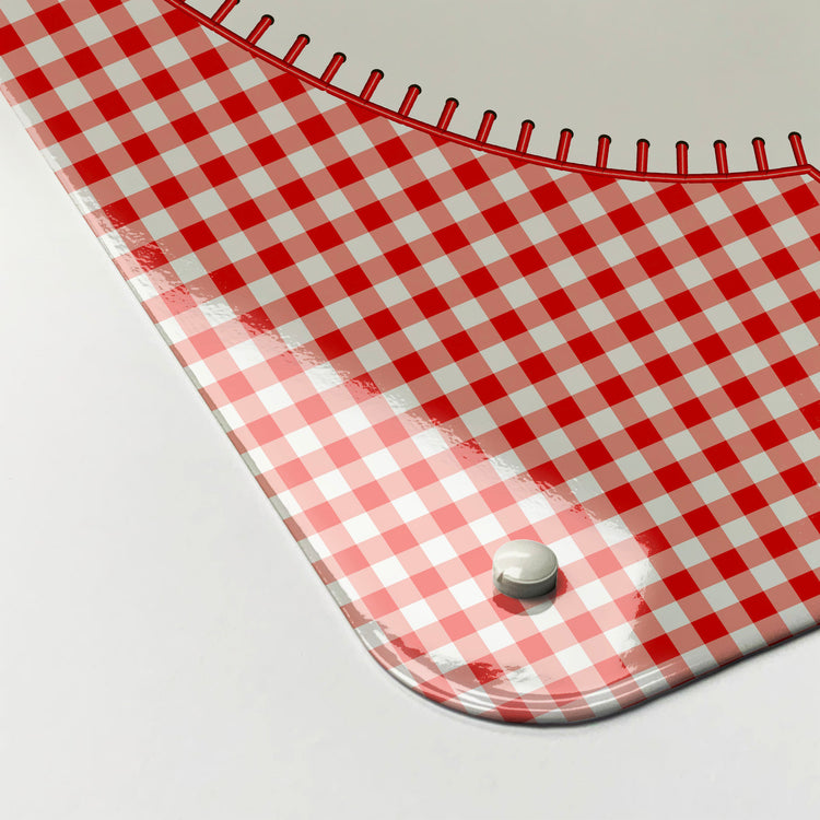 The corner detail of an appliqué teapot on red gingham design magnetic board to show it’s high gloss surface