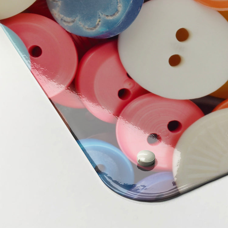 The corner detail of a buttons photographic magnetic board to show it’s high gloss surface