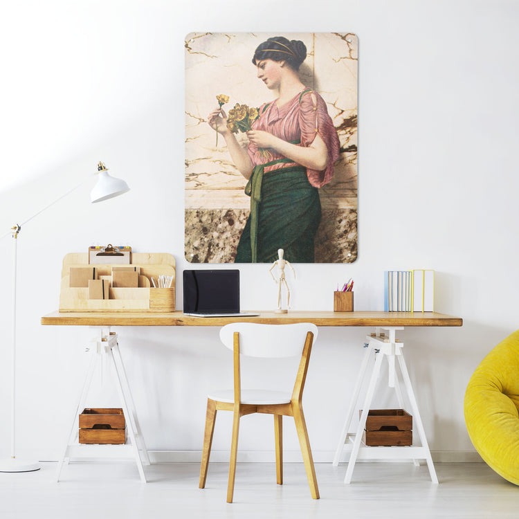 A desk in a workspace setting in a white interior with a magnetic metal wall art panel showing Crytilla a painting of a woman holding flowers