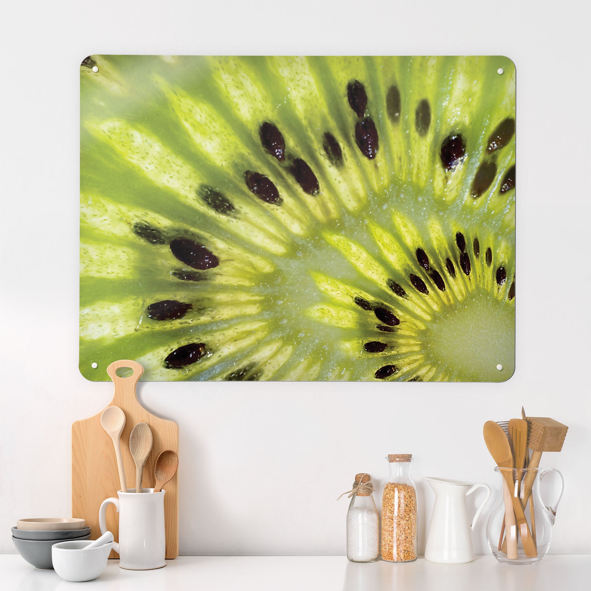A kitchen  interior with a magnetic metal wall art panel showing a close up photograph of a slice of green Kiwi fruit