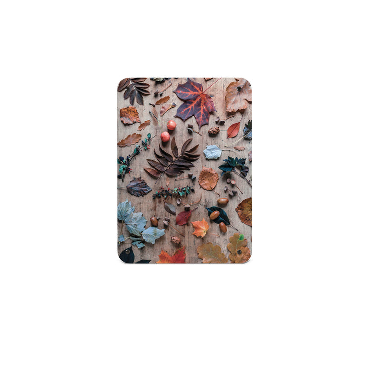 A small magnetic notice board by Beyond the Fridge with a photograph of a flatly of autumn leaves and acorns on a wooden background