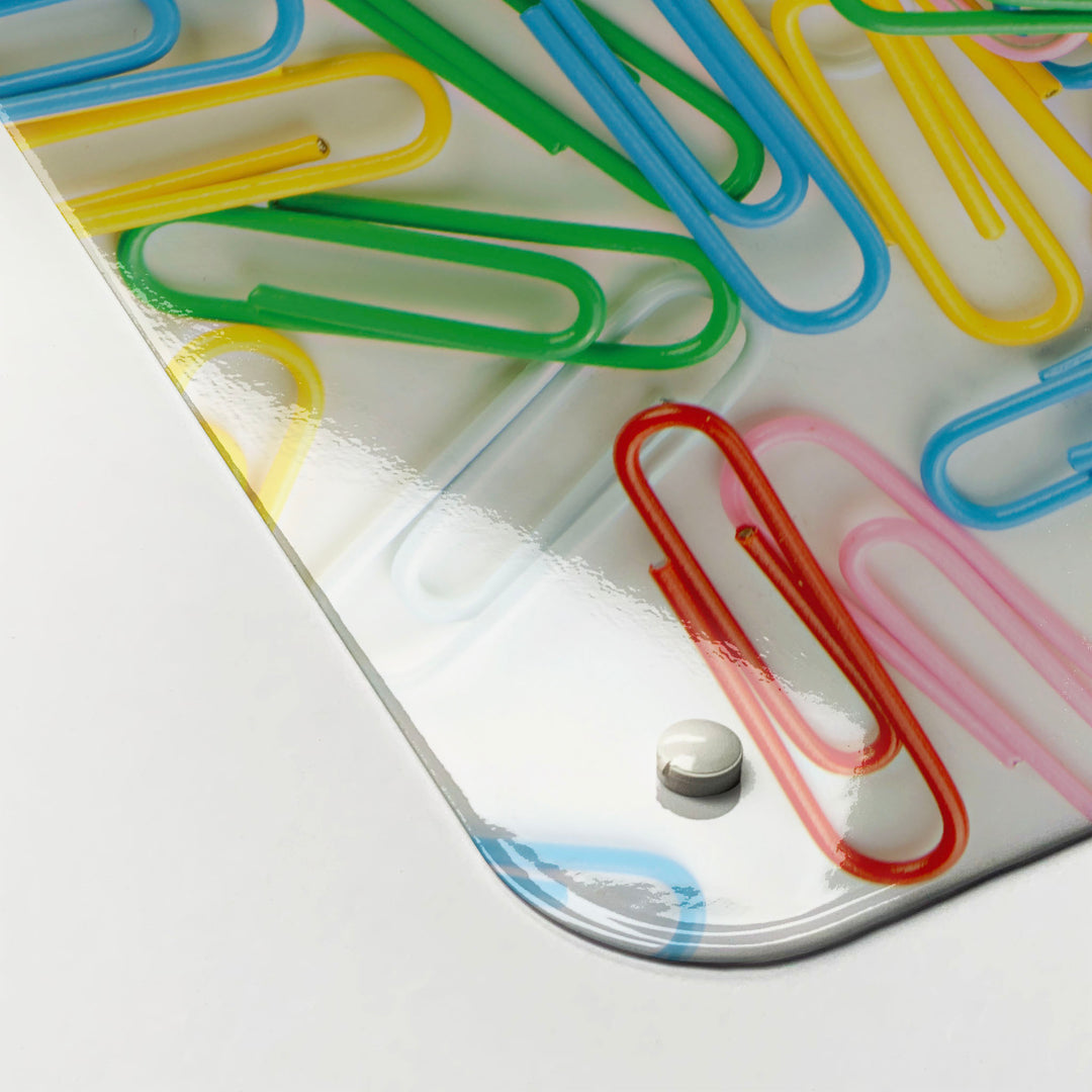 The corner detail of a paper clips photographic magnetic board to show it’s high gloss surface
