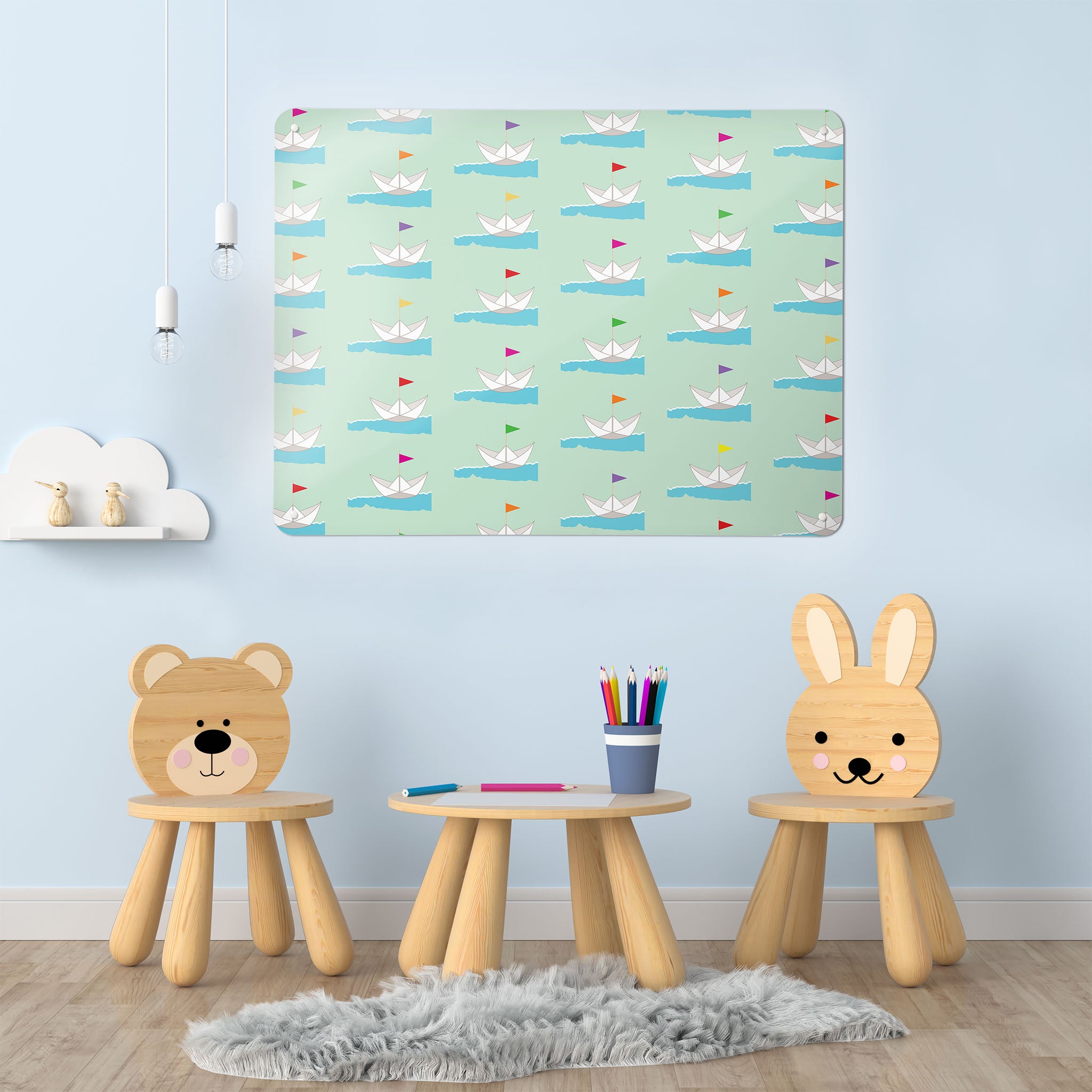 A playroom interior with a magnetic metal wall art panel showing a paper boats design with coloured flags on a pale green background