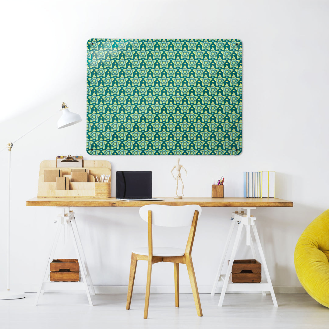 A desk in a workspace setting in a white interior with a magnetic metal wall art panel showing a stars on teal  repeat pattern design