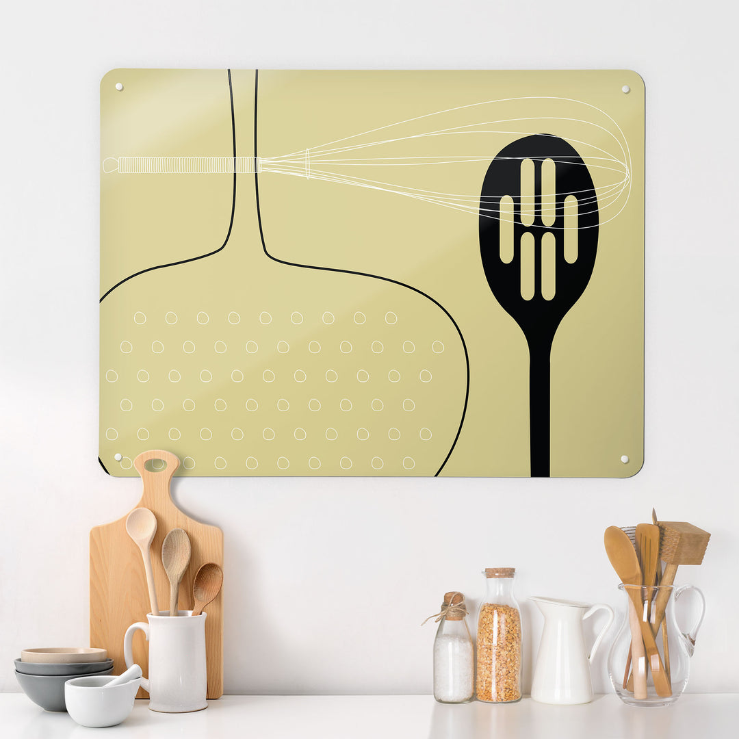 A kitchen interior with a magnetic metal wall art panel showing a light olive utensils design