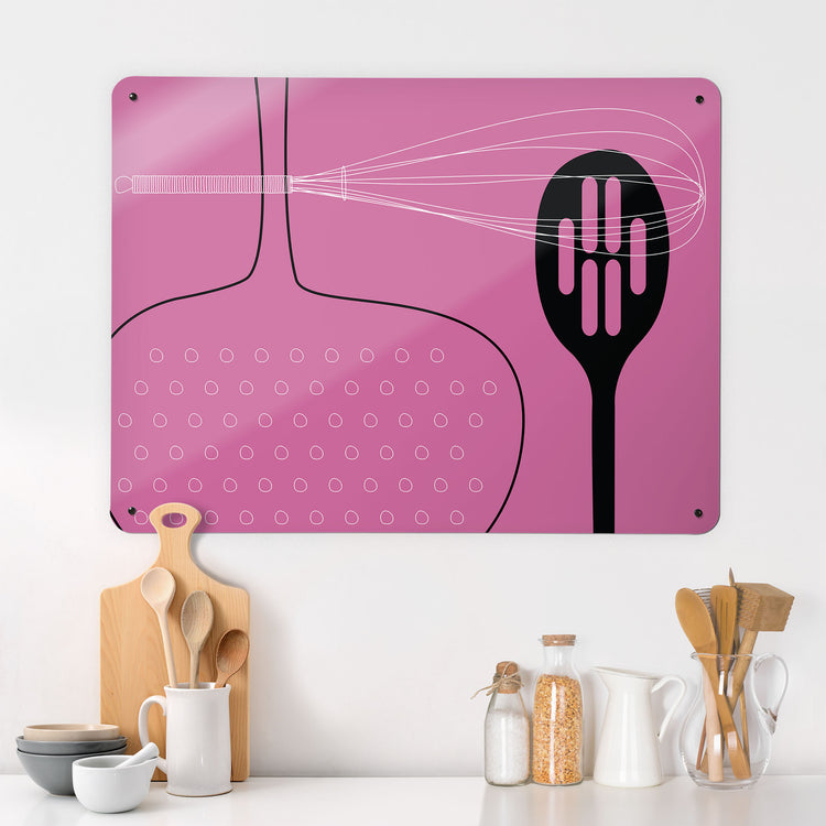 A kitchen interior with a magnetic metal wall art panel showing a pink utensils design