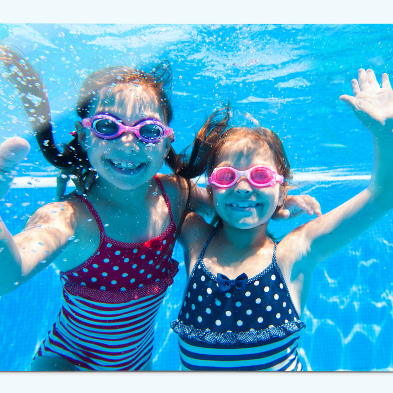 two children under water waving to the camera on a create your own magnetic board metal wall art panel by Beyond the Fridge