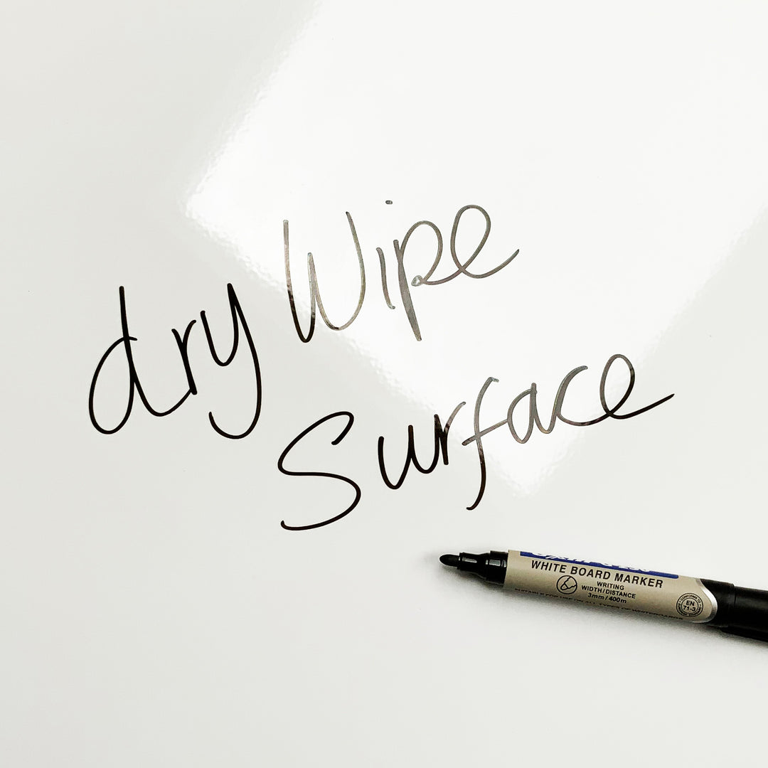 A dry wipe plain white steel magnetic board with 'dry wipe surface' written on it with a whiteboard marker