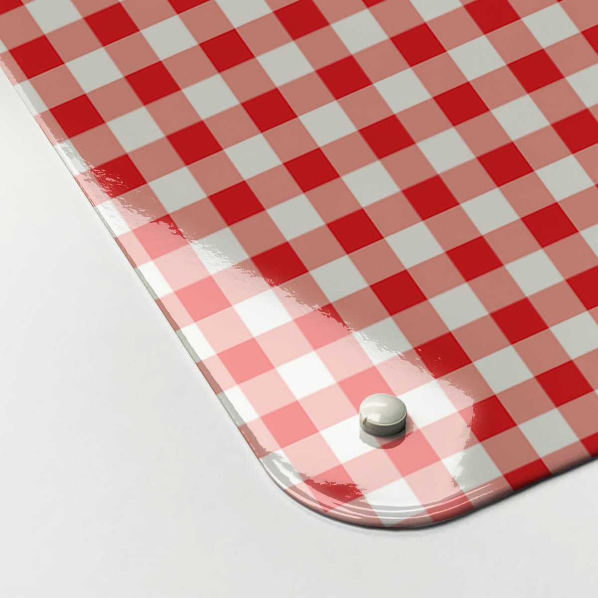Close-up of the corner of the Applique Heart On Red Gingham magnetic notice board in Applique Heart on Red Gingham, showing the gloss finish and a screw cap