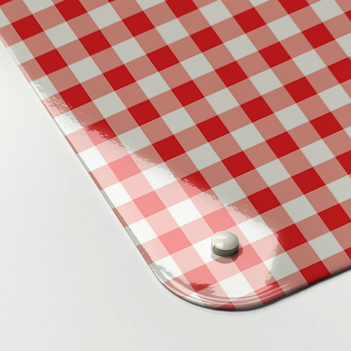 Close-up of the corner of the Applique Teapot On Gingham magnetic notice board in Applique Teapot on Red Gingham, showing the gloss finish and a screw cap