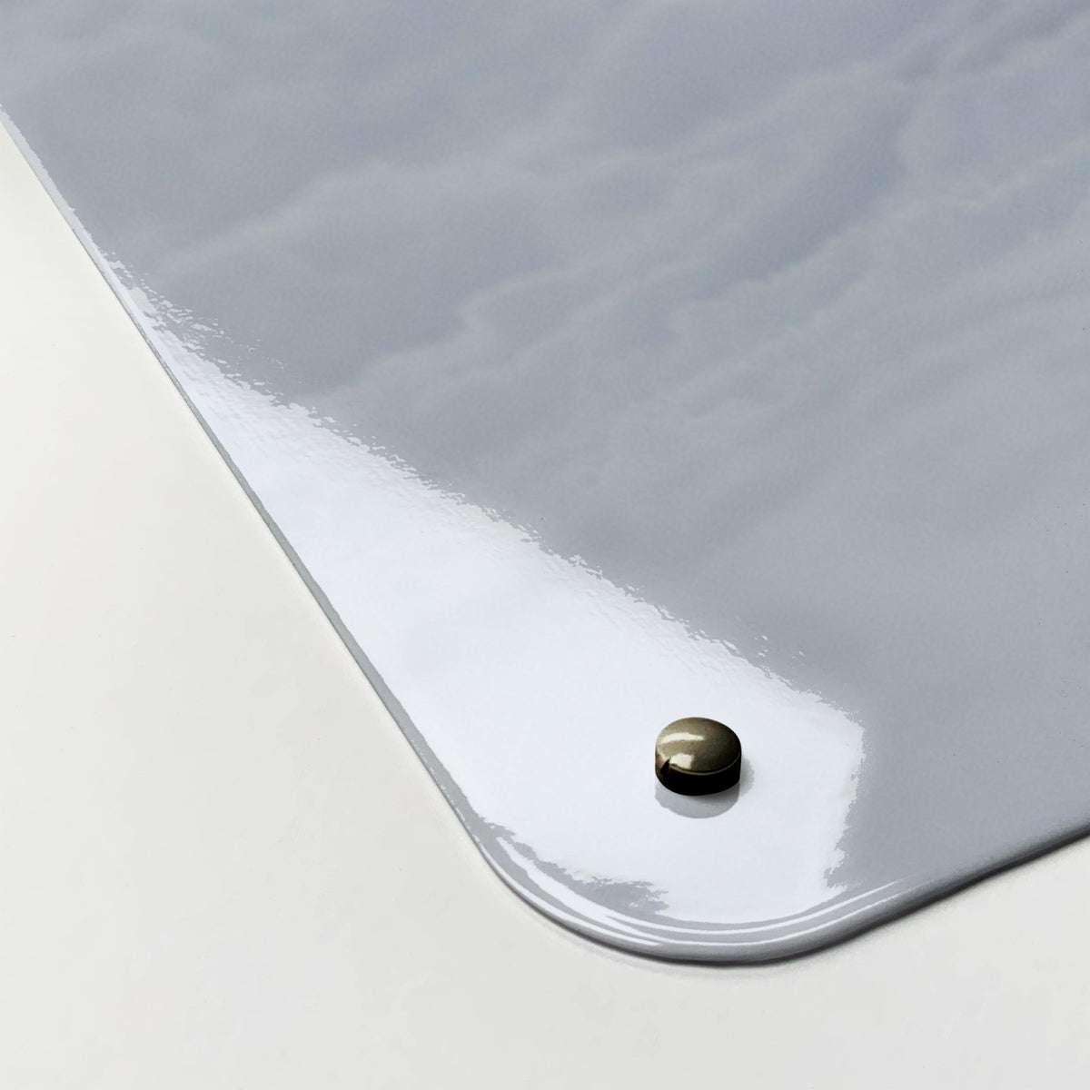 Close-up of the corner of the Artic Fox magnetic notice board, showing the gloss finish and a screw cap