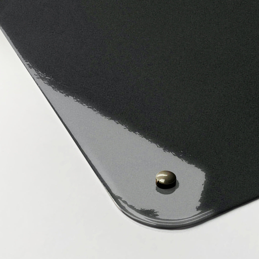 Close-up of the corner of the Balancing Stones magnetic notice board, showing the gloss finish and a screw cap