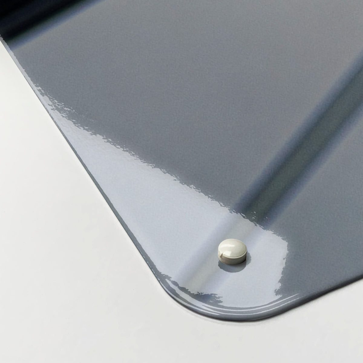 Close-up of the corner of the Bicycle Spokes magnetic notice board, showing the gloss finish and a screw cap