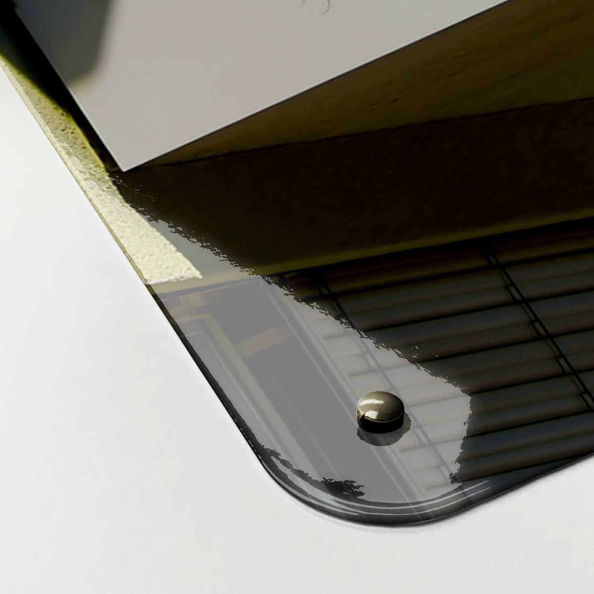 Close-up of the corner of the Brutalist Balconies magnetic notice board, showing the gloss finish and a screw cap