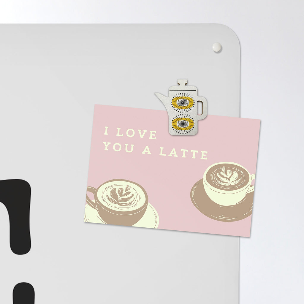 A postcard held by a fridge magnet on the Coffee Quote magnetic notice board