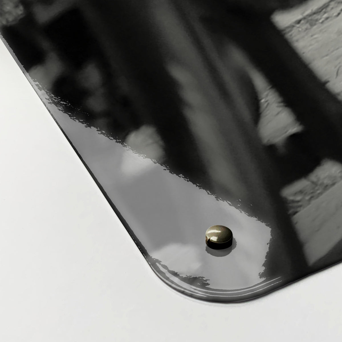 Close-up of the corner of the Cyclists magnetic notice board, showing the gloss finish and a screw cap