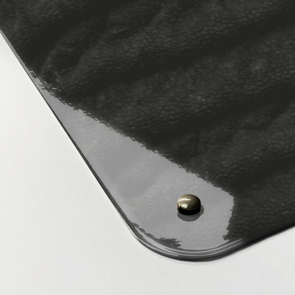 Close-up of the corner of the Elephant magnetic notice board, showing the gloss finish and a screw cap