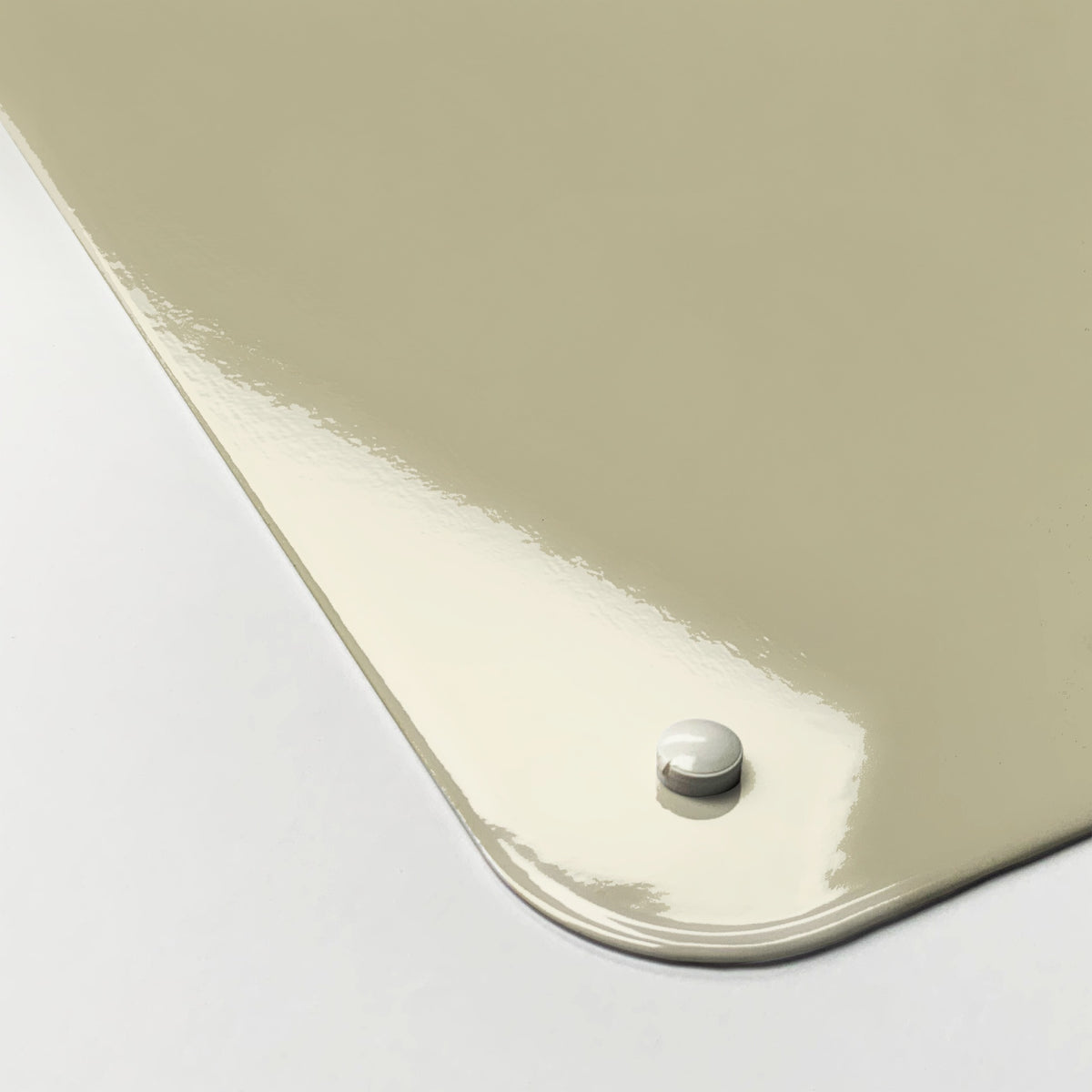 Close-up of the corner of the Fair Isle Owl magnetic notice board in Olive/Coral, showing the gloss finish and a screw cap