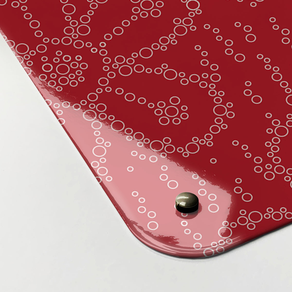 Close-up of the corner of the Fizzy Flowers magnetic notice board in Cherryade, showing the gloss finish and a screw cap