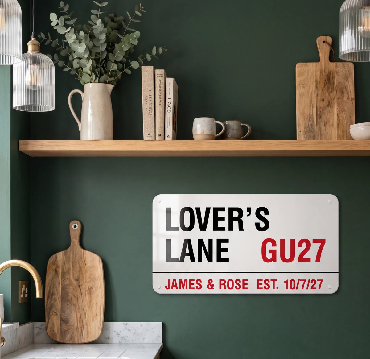 A personalised street sign reading Lover’s Lane GU27, James & Rose, Est. 10/7/27, on a green kitchen wall