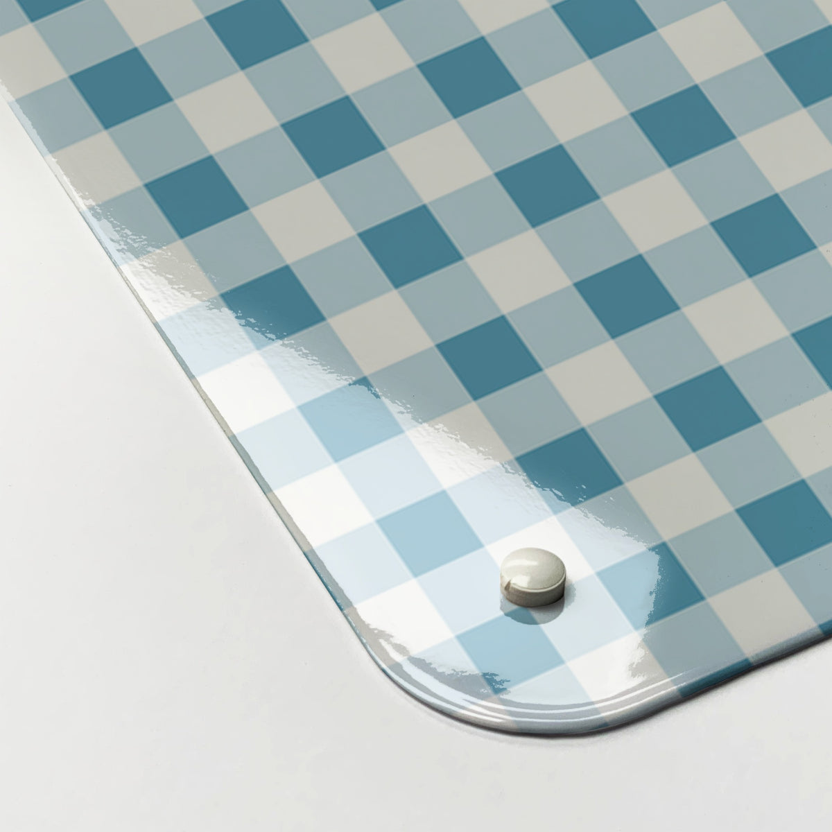 Close-up of the corner of the Gingham magnetic notice board in Blue, showing the gloss finish and a screw cap