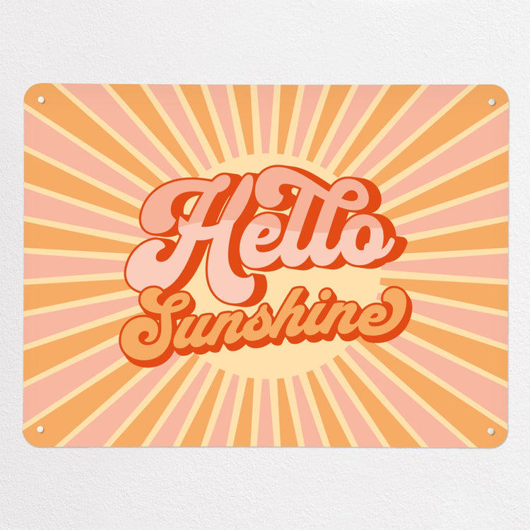 A large steel magnetic board with a print of a typographic quote design that reads Hello Sunshine with a sunburst in pink and orange colours