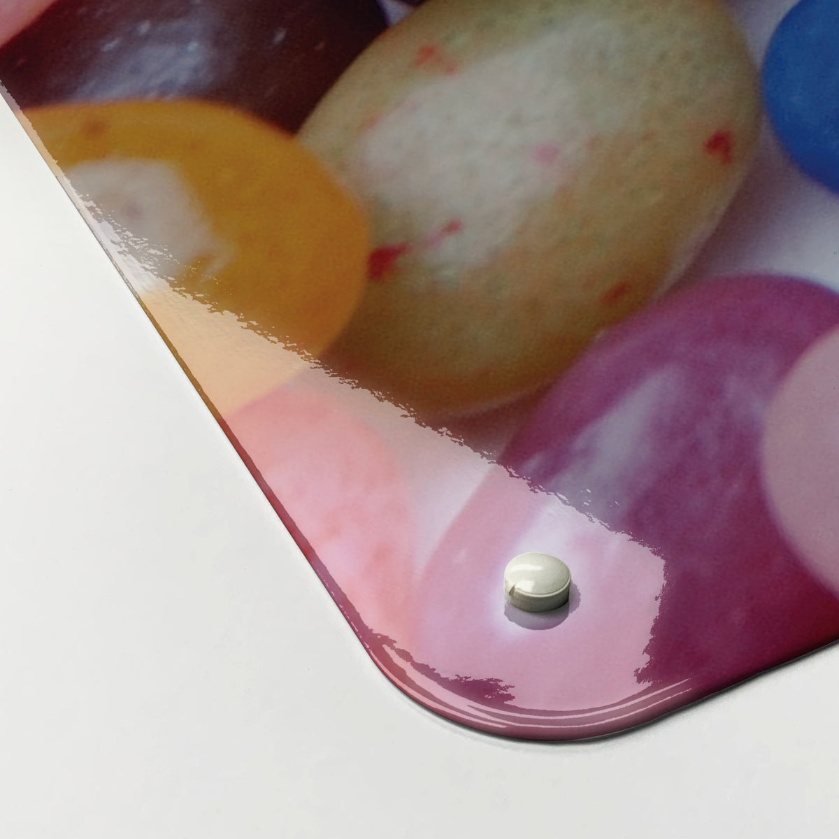 Close-up of the corner of the Jelly Beans magnetic notice board in Jelly Beans, showing the gloss finish and a screw cap
