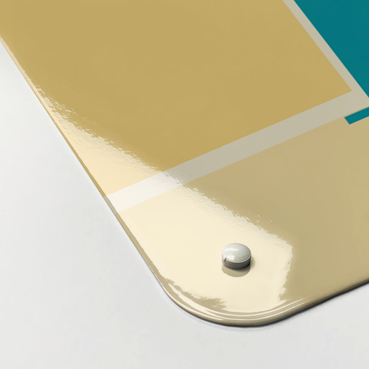 Close-up of the corner of the Kitchen Disco magnetic notice board in Teal, showing the gloss finish and a screw cap