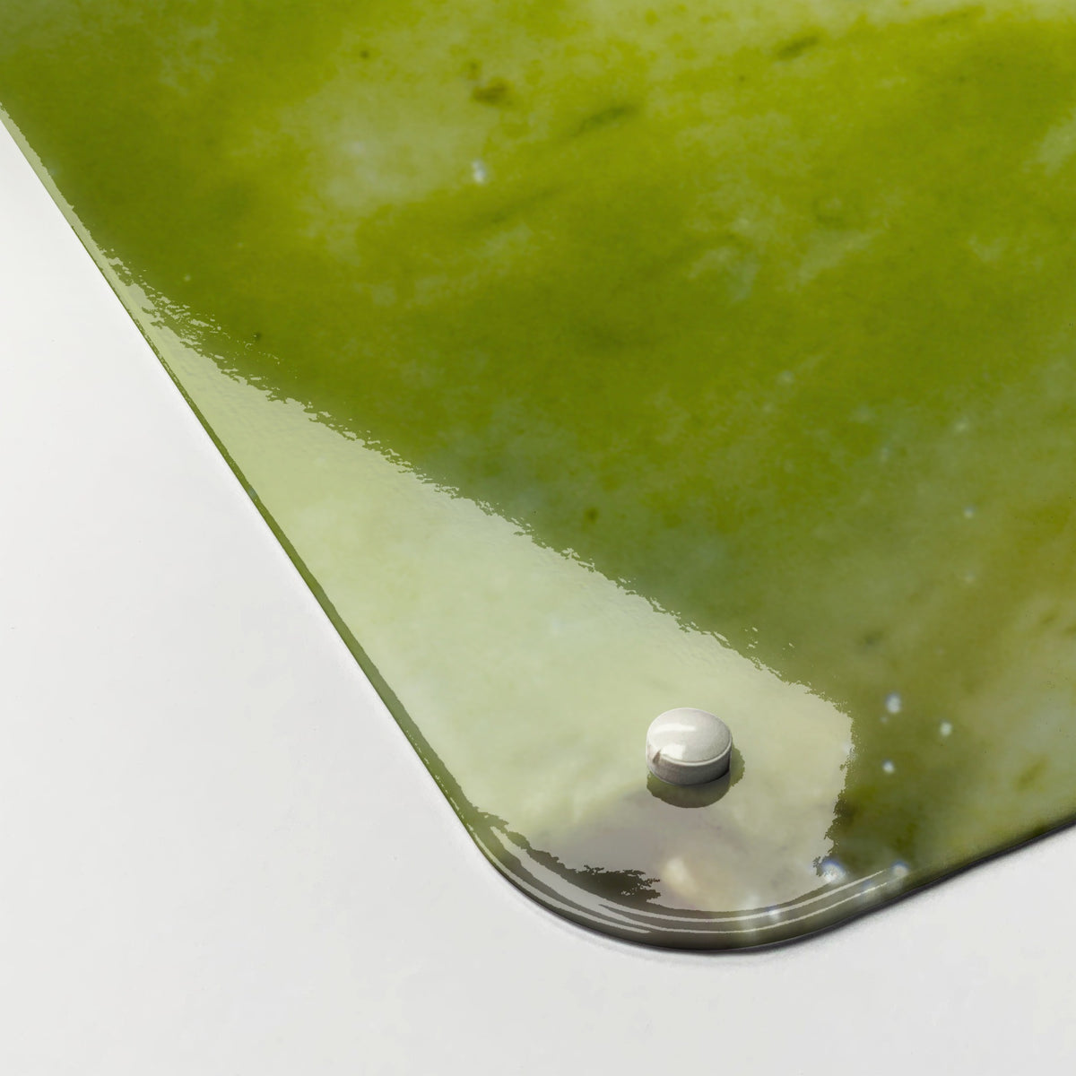 Close-up of the corner of the Kiwi magnetic notice board, showing the gloss finish and a screw cap