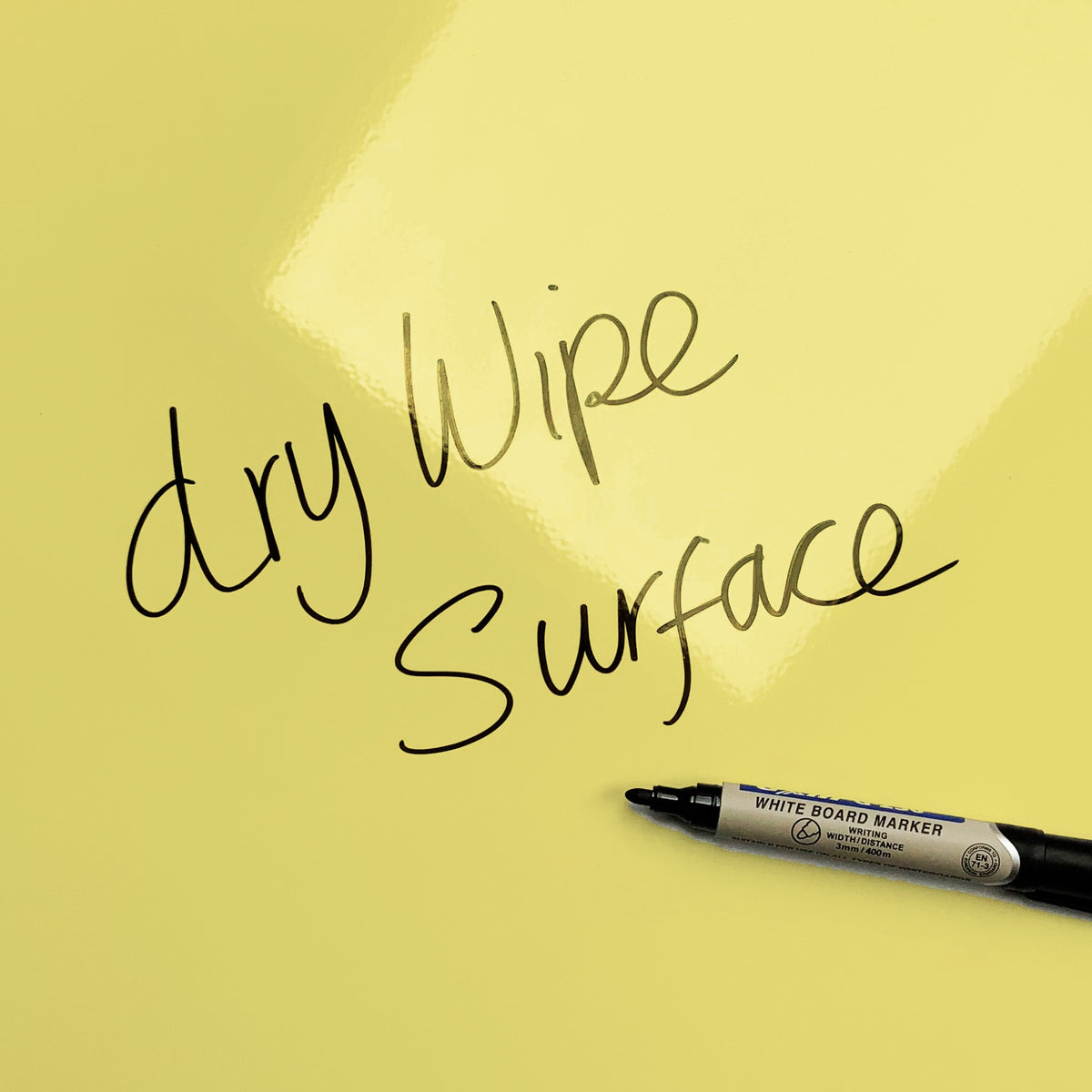 The words dry wipe surface written in marker pen on the Plain Yellow magnetic notice board
