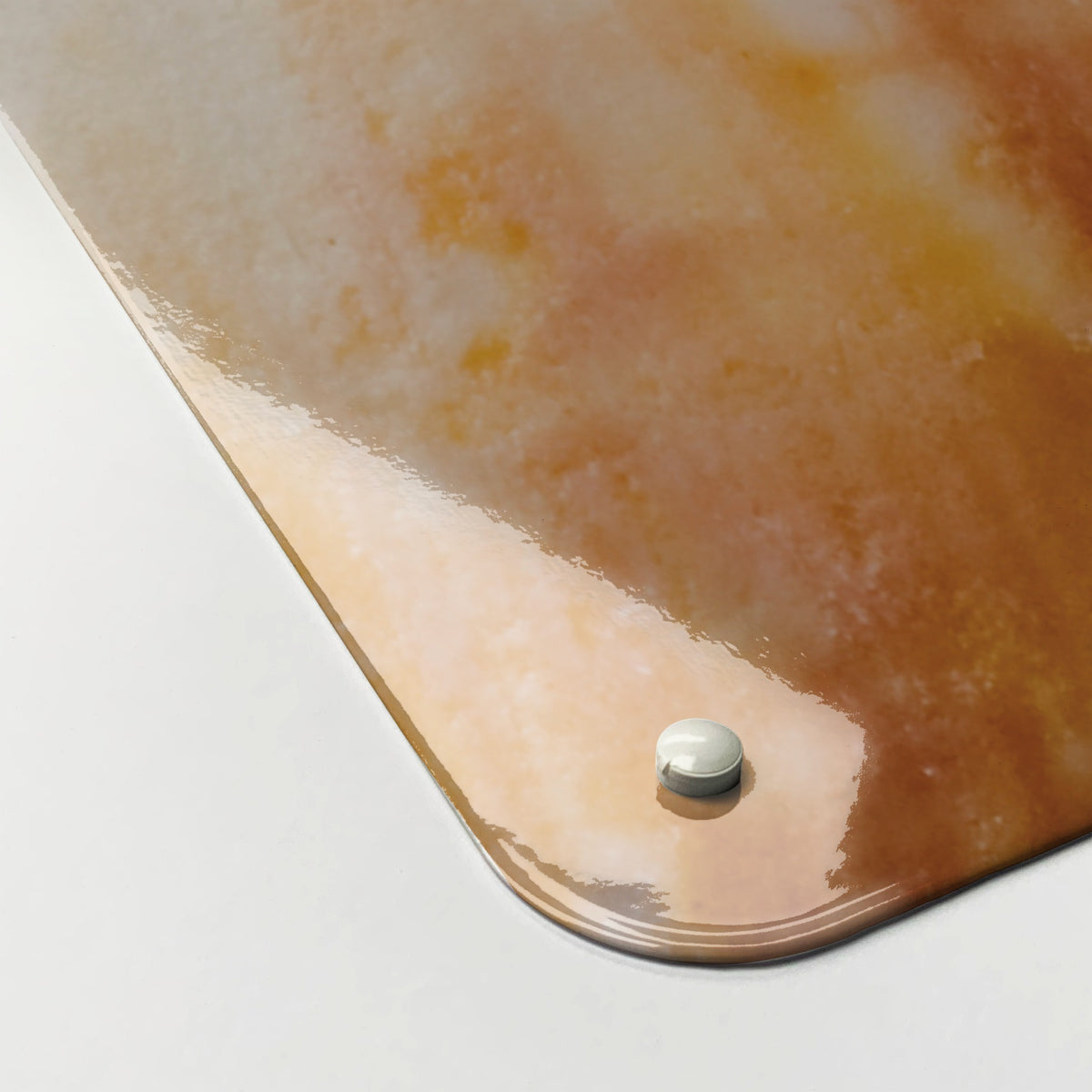 Close-up of the corner of the Shells magnetic notice board in Shells, showing the gloss finish and a screw cap