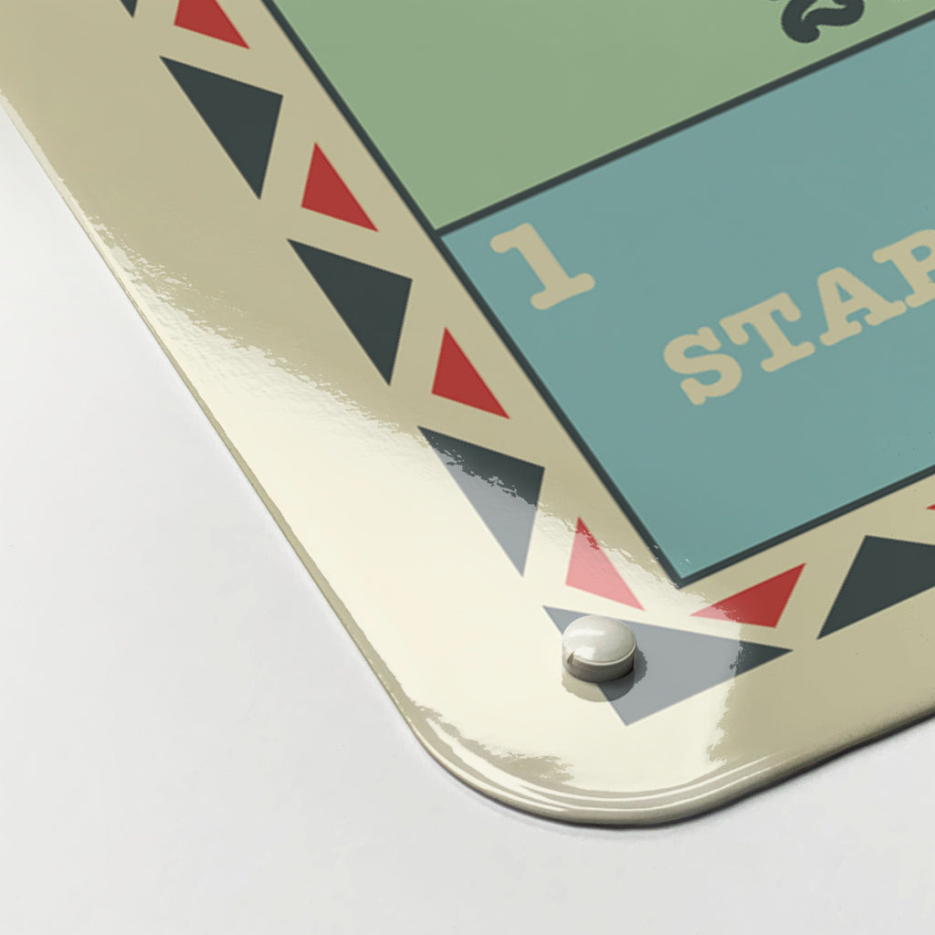 Close-up of the corner of the Snakes And Ladders magnetic notice board in Snakes and Ladders, showing the gloss finish and a screw cap