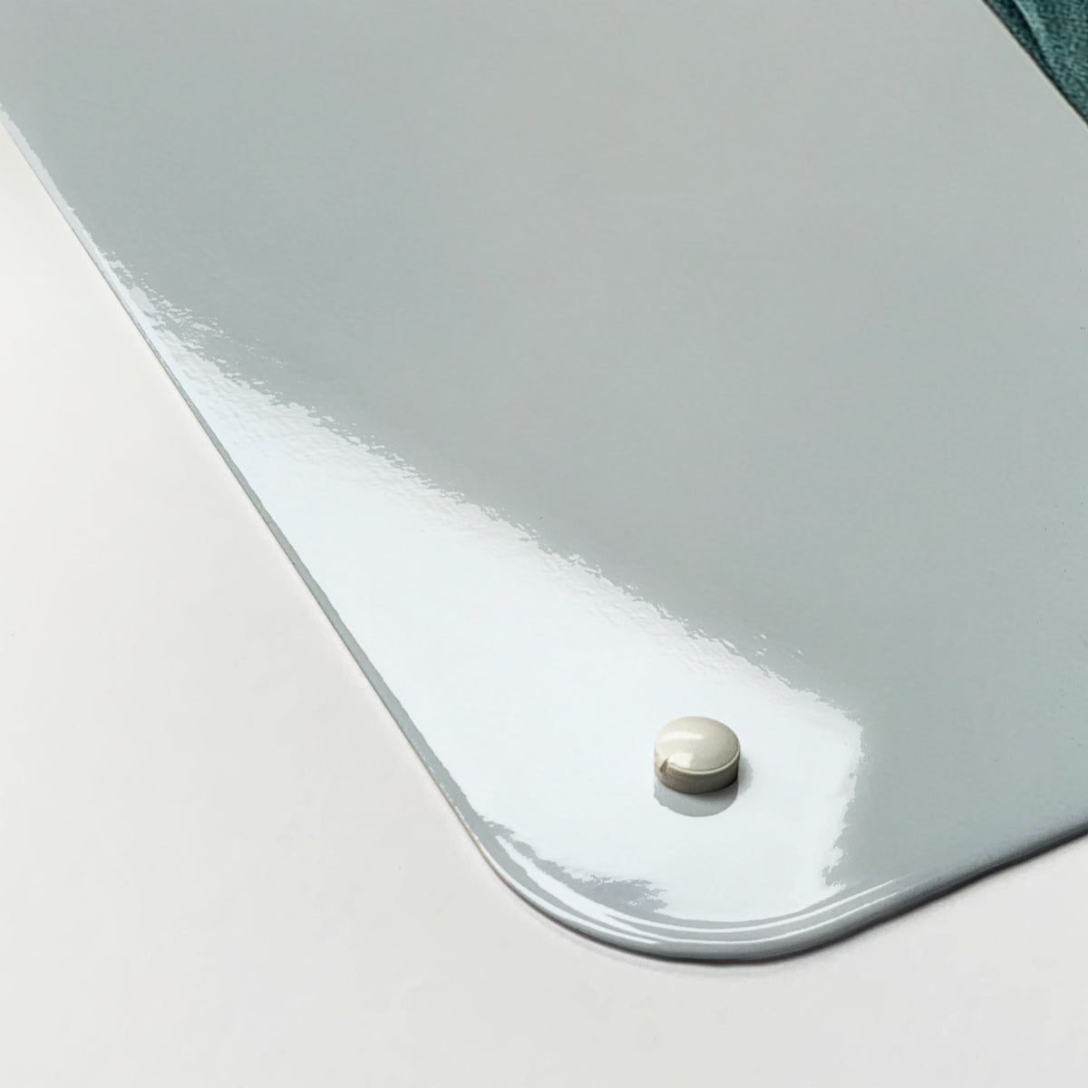 Close-up of the corner of the Statue Of Liberty magnetic notice board, showing the gloss finish and a screw cap