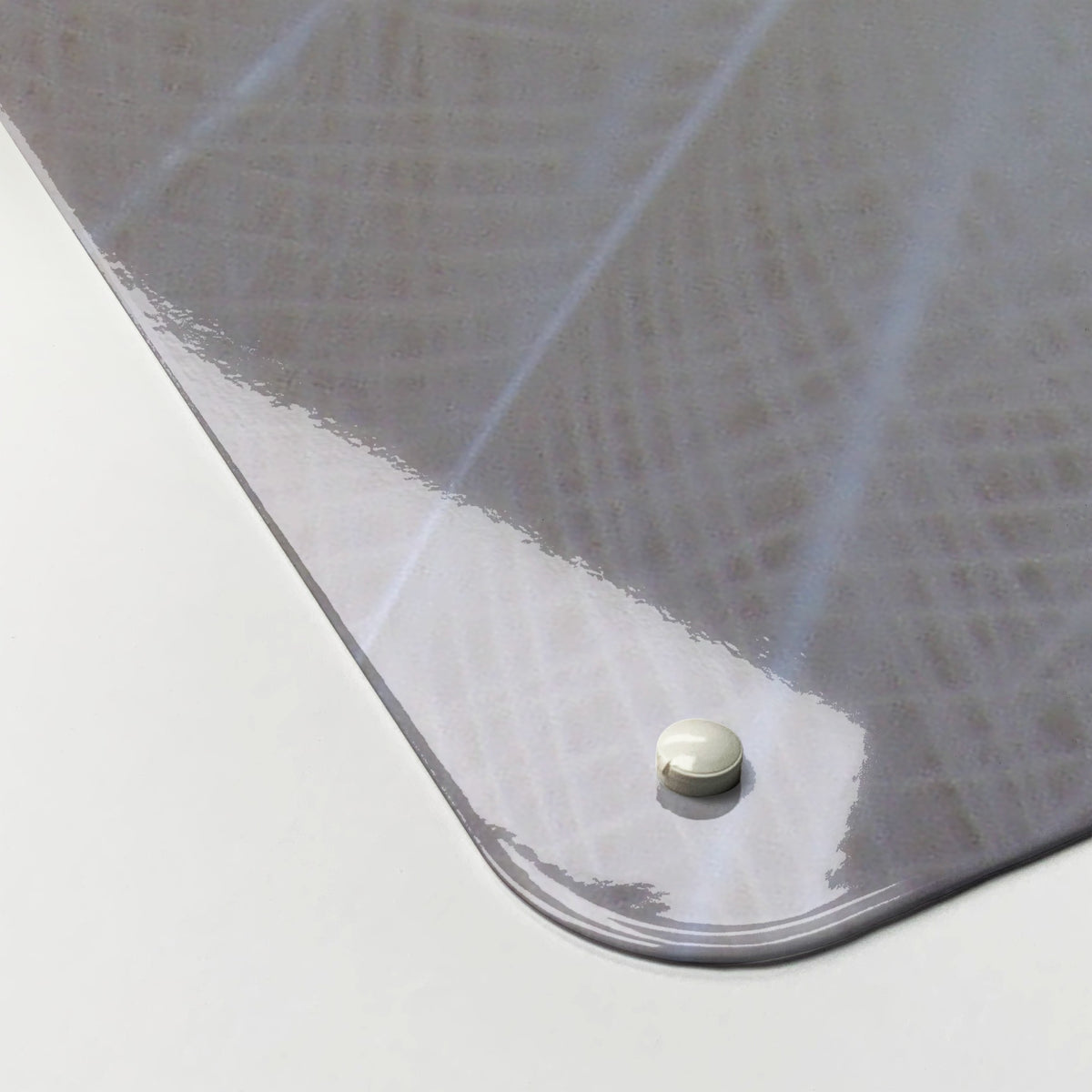 Close-up of the corner of the White Peacock magnetic notice board, showing the gloss finish and a screw cap