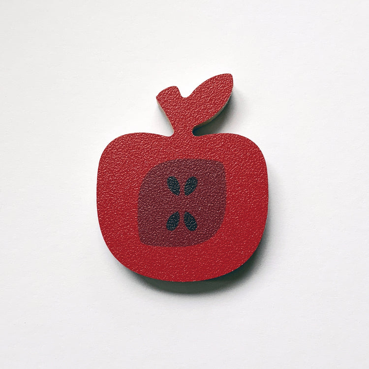 A red apple shaped plywood fridge magnet by Beyond the Fridge