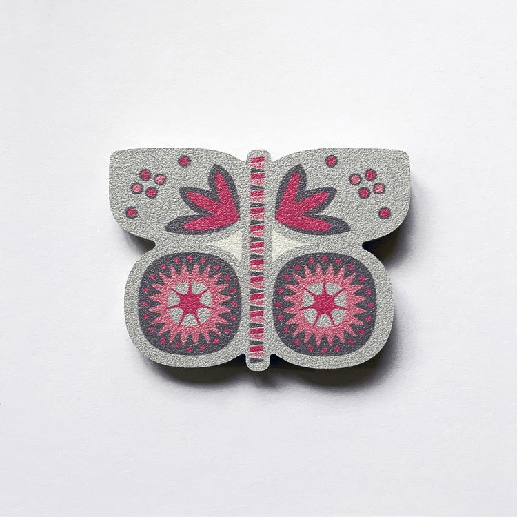 A grey butterfly shaped plywood fridge magnet by Beyond the Fridge