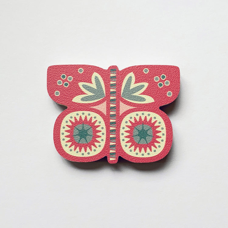 A pink butterfly shaped plywood fridge magnet by Beyond the Fridge