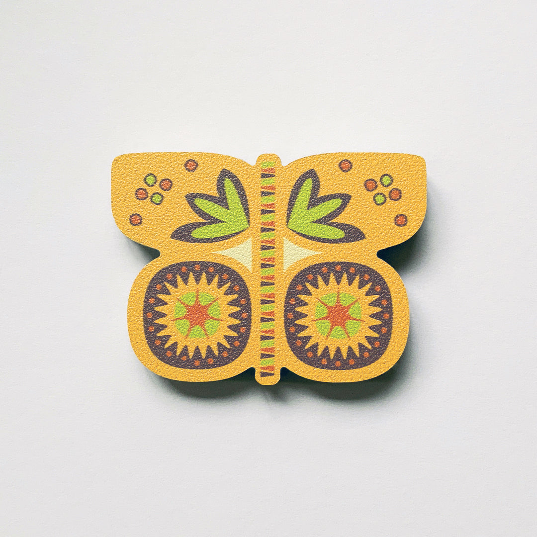 A yellow butterfly shaped plywood fridge magnet by Beyond the Fridge