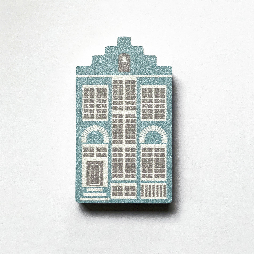 A blue Delft house shaped plywood fridge magnet by Beyond the Fridge