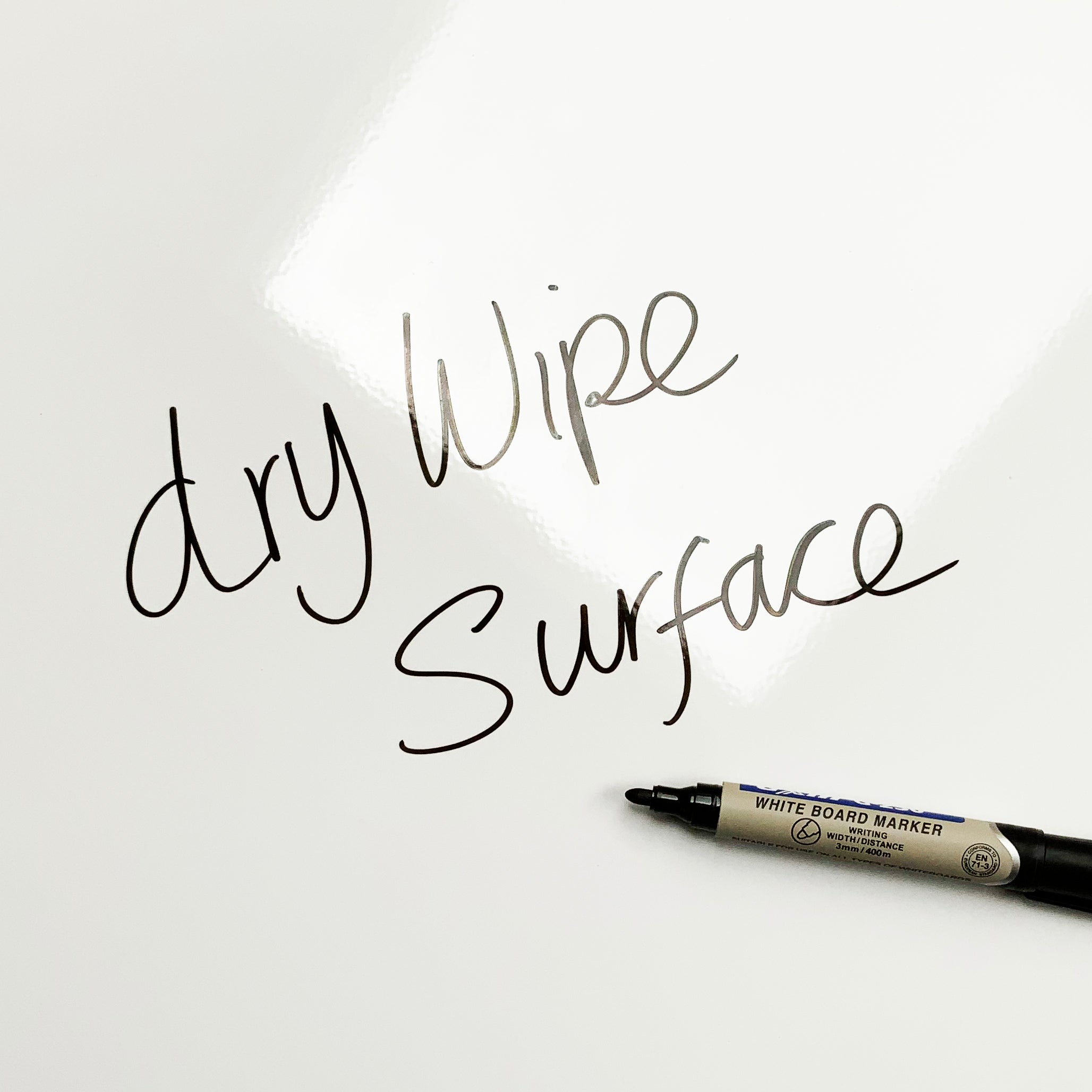 A plain white magnetic board with dry wipe surface written on it with a whiteboard marker pen