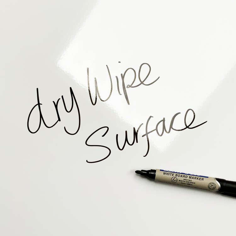 A plain white magnetic board with dry wipe surface written on it with a dry erase marker pen