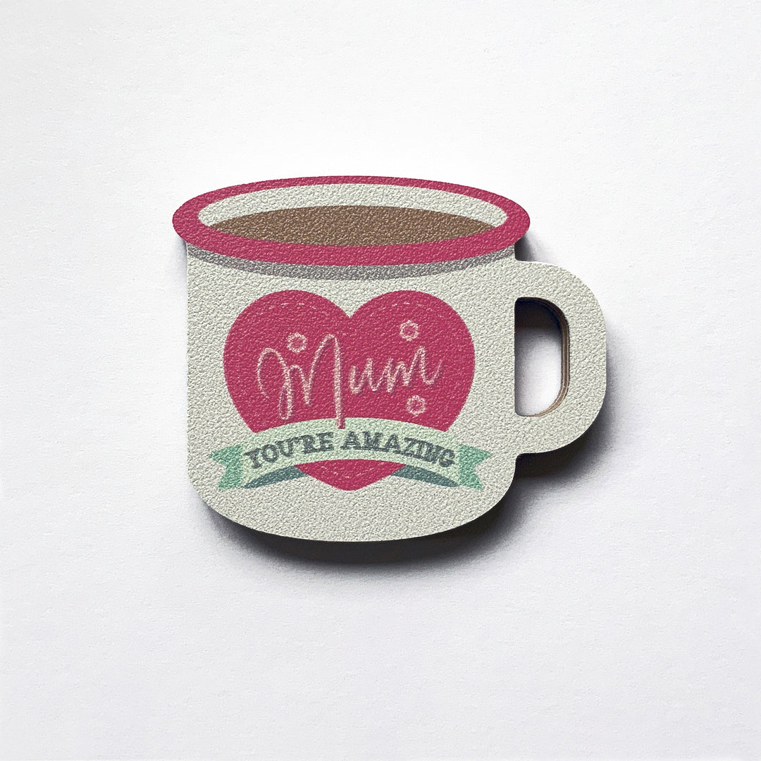 An enamel mug shaped plywood fridge magnet by Beyond the Fridge with an pink heart with mum you're amazing on it
