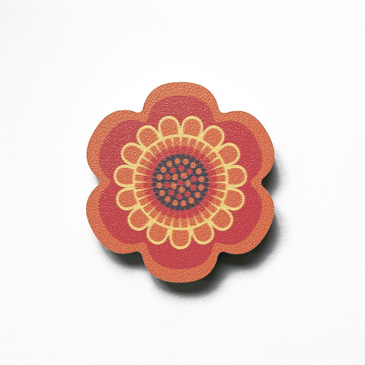 An orange flower shaped plywood fridge magnet by Beyond the Fridge