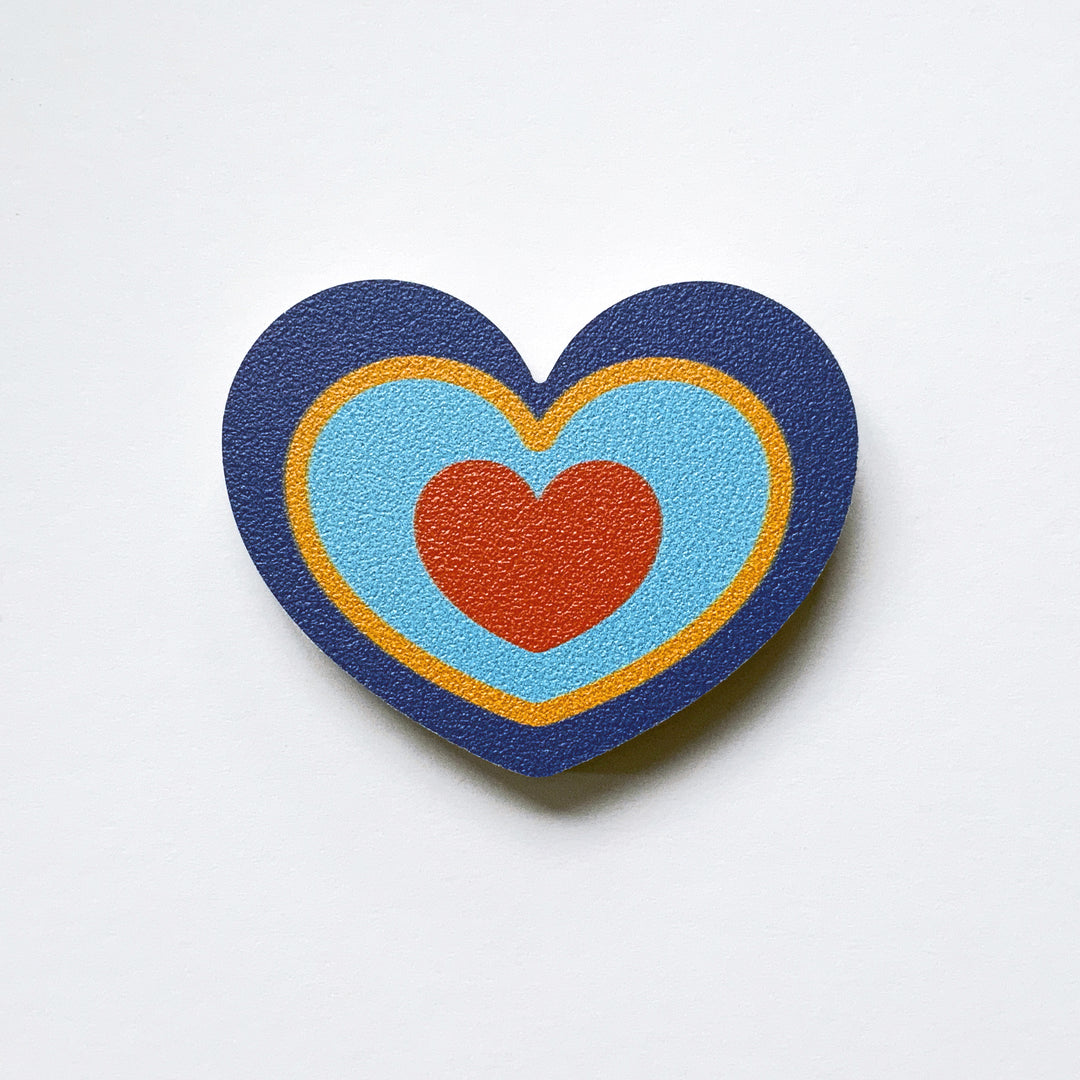 A blue, yellow and red heart shaped plywood fridge magnet by Beyond the Fridge