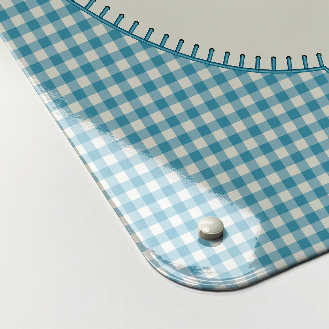 The corner detail of an appliqué teapot on blue gingham design magnetic board to show it’s high gloss surface