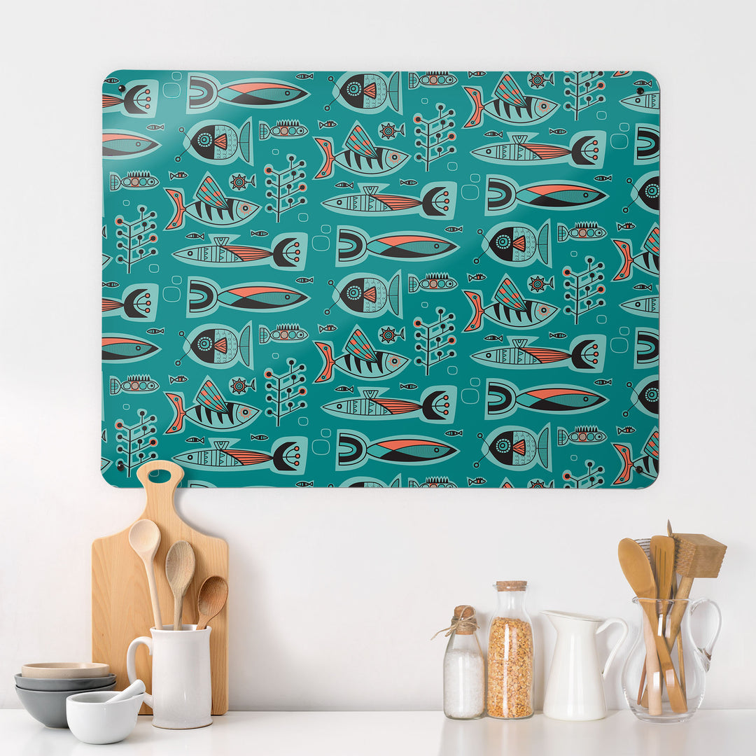 A kitchen interior with a magnetic metal wall art panel showing a retro style repeat pattern of aquarium fish in aqua colours