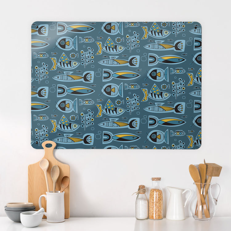 A kitchen interior with a magnetic metal wall art panel showing a retro style repeat pattern of aquarium fish in blue and yellow colours