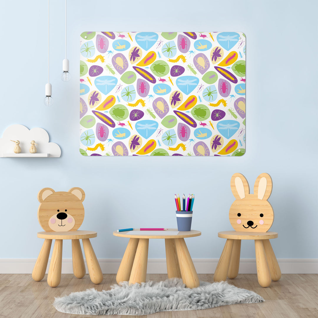 A desk in a playroom  interior with a magnetic metal wall art panel showing a bugs design in bright colours